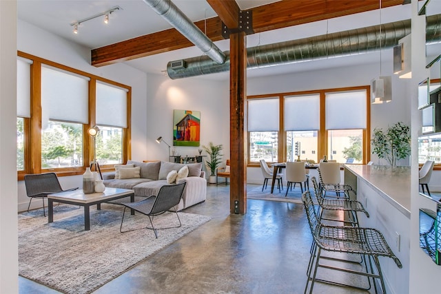 living room with a towering ceiling and concrete flooring