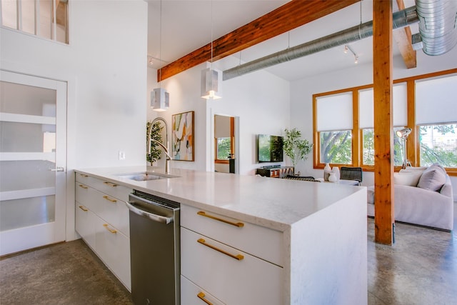 kitchen with light stone countertops, pendant lighting, white cabinetry, and sink