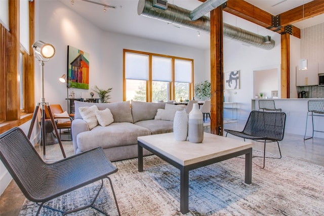 living room with a towering ceiling and concrete floors