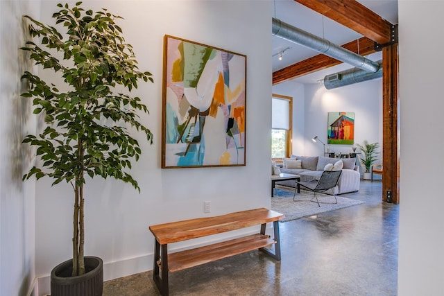 hall featuring beam ceiling and concrete floors