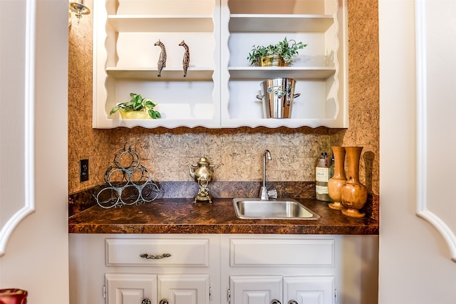 bar with white cabinetry, sink, and tasteful backsplash