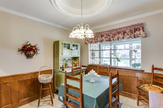 dining room featuring crown molding, a chandelier, and wooden walls