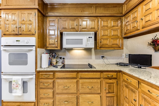 kitchen with white appliances, backsplash, and light stone counters