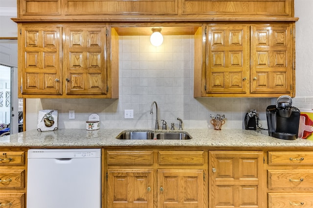 kitchen with light stone countertops, decorative backsplash, sink, and dishwasher