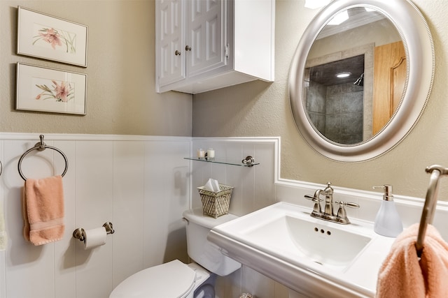 bathroom with walk in shower, sink, and toilet