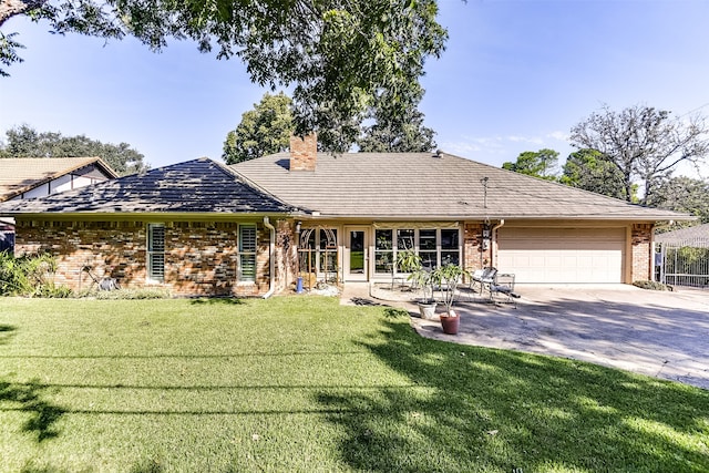 rear view of house with a garage and a yard