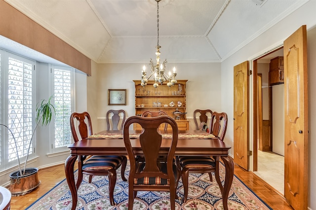 dining room featuring ornamental molding, vaulted ceiling, an inviting chandelier, and light parquet flooring