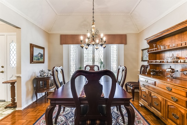 dining area with dark parquet flooring, lofted ceiling, ornamental molding, and a chandelier