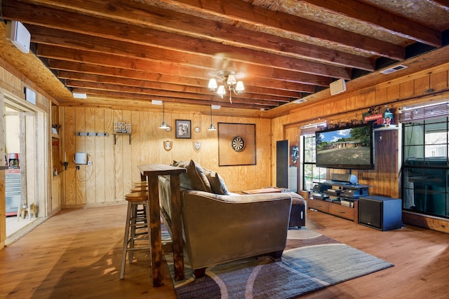 living room with beam ceiling, hardwood / wood-style flooring, and wooden walls