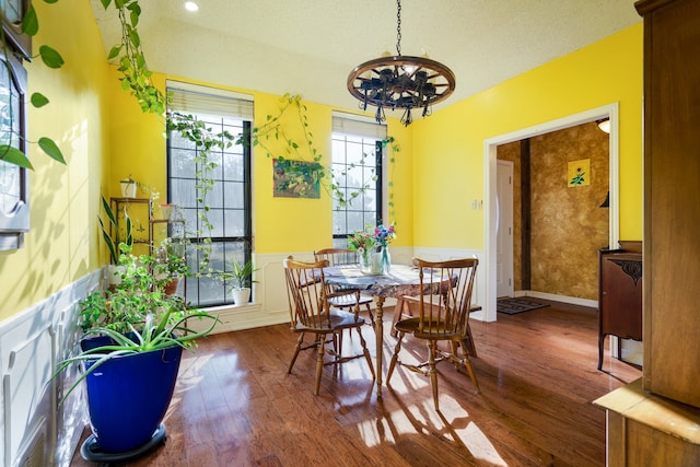 dining area featuring hardwood / wood-style flooring, a chandelier, and a textured ceiling