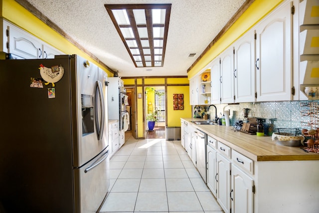 kitchen featuring white cabinets, a textured ceiling, stainless steel appliances, and sink