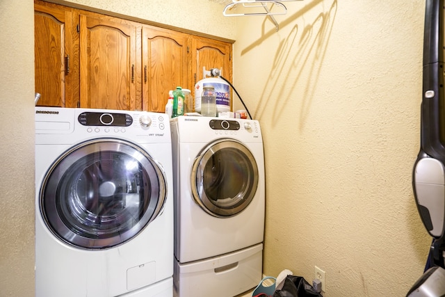 laundry room featuring washing machine and dryer and cabinets