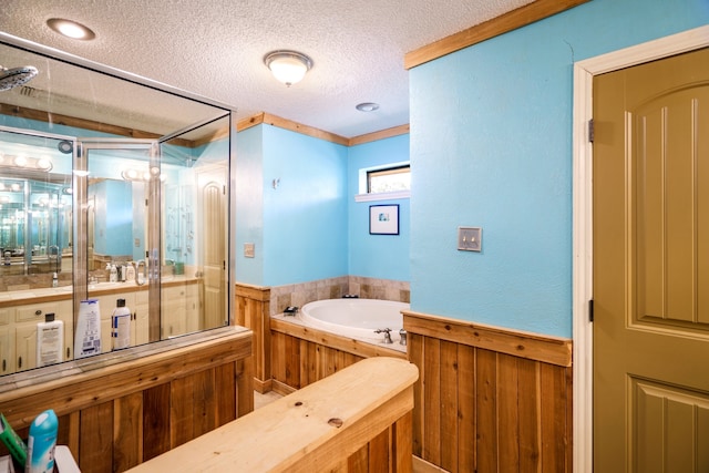 bathroom with vanity, a textured ceiling, wooden walls, and a bath