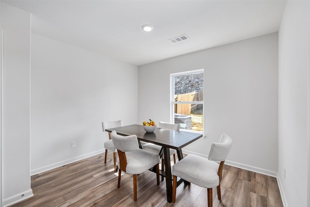 dining space with wood-type flooring