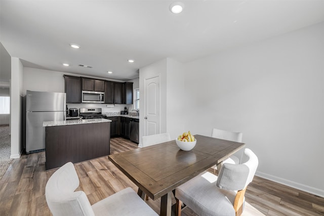 dining area with sink and light hardwood / wood-style flooring