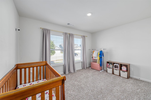 bedroom with a crib and carpet floors