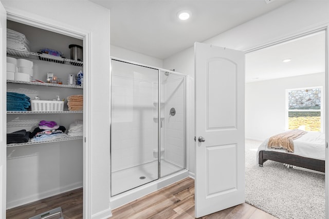 bathroom featuring wood-type flooring and an enclosed shower