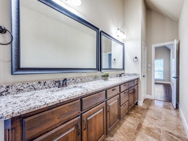 bathroom with vanity and lofted ceiling