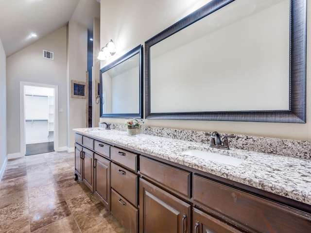 bathroom with vanity and high vaulted ceiling