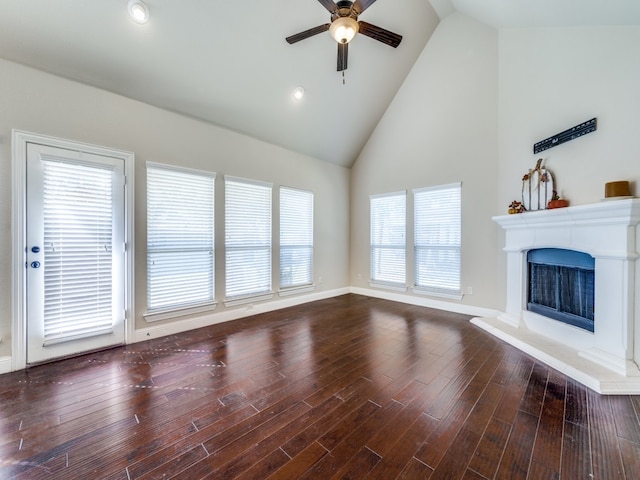 unfurnished living room with high vaulted ceiling, dark wood-type flooring, and ceiling fan