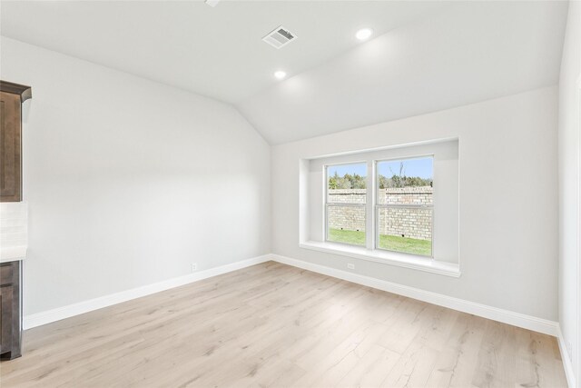 carpeted spare room featuring vaulted ceiling and ceiling fan