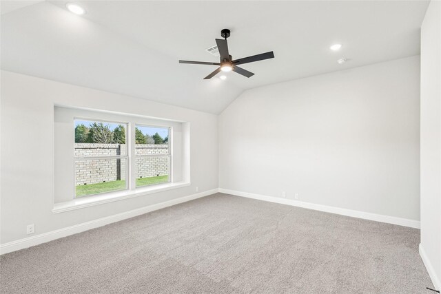 spare room with vaulted ceiling, ceiling fan, and carpet flooring