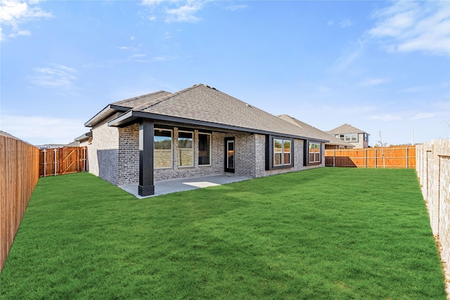 rear view of house with a lawn and a patio