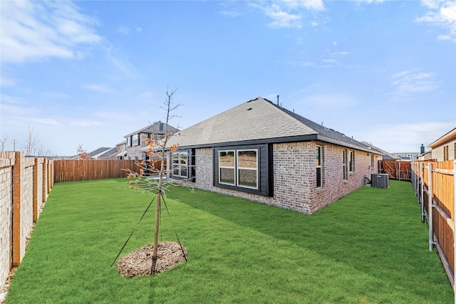 back of house featuring a lawn and cooling unit