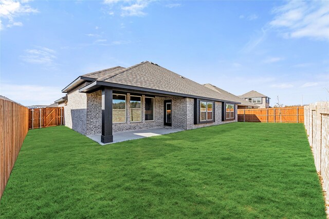 rear view of house featuring a patio area and a lawn