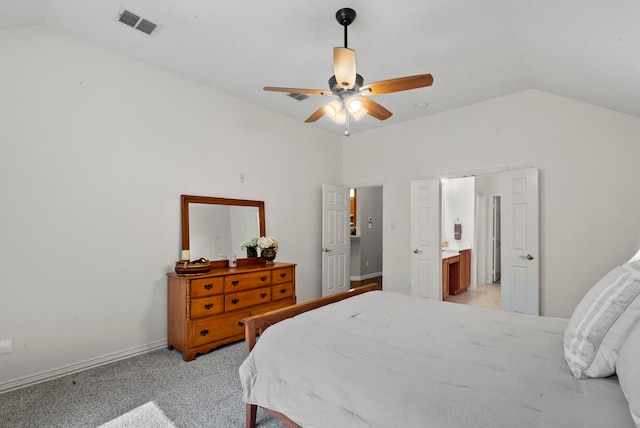 bedroom with lofted ceiling, ceiling fan, ensuite bathroom, and light colored carpet