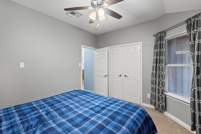 carpeted bedroom featuring vaulted ceiling, ceiling fan, and a closet