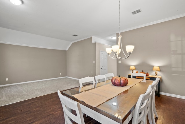 dining space featuring a notable chandelier, dark wood-type flooring, crown molding, and vaulted ceiling