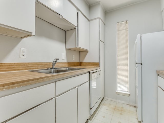 kitchen featuring white appliances, sink, and white cabinetry