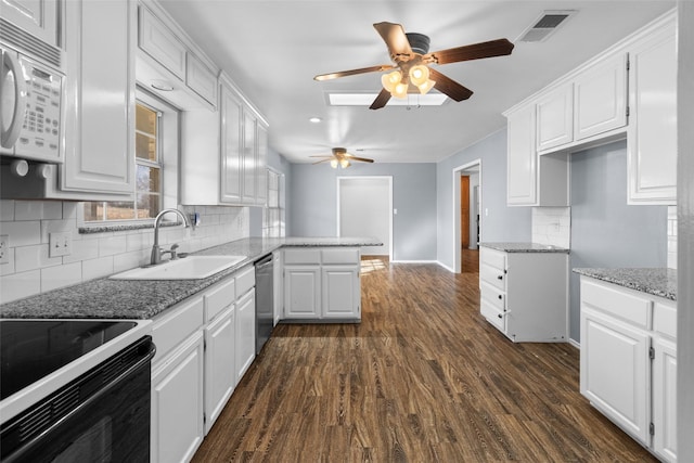 kitchen featuring visible vents, white microwave, white cabinetry, a sink, and dishwasher