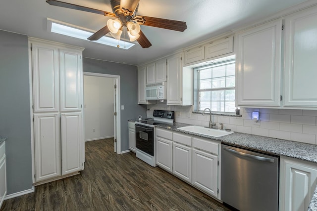 kitchen featuring backsplash, white appliances, sink, dark hardwood / wood-style floors, and white cabinetry