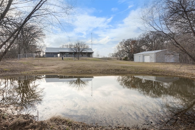 view of yard featuring an outbuilding, a water view, and a detached garage