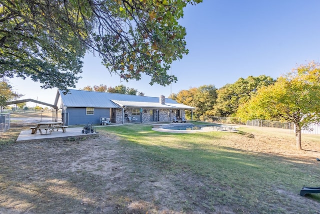 rear view of property featuring a yard and a patio