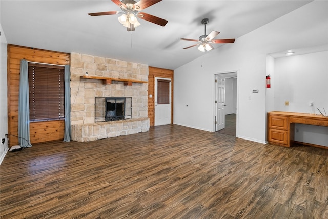 unfurnished living room with a stone fireplace, wood finished floors, a ceiling fan, baseboards, and vaulted ceiling