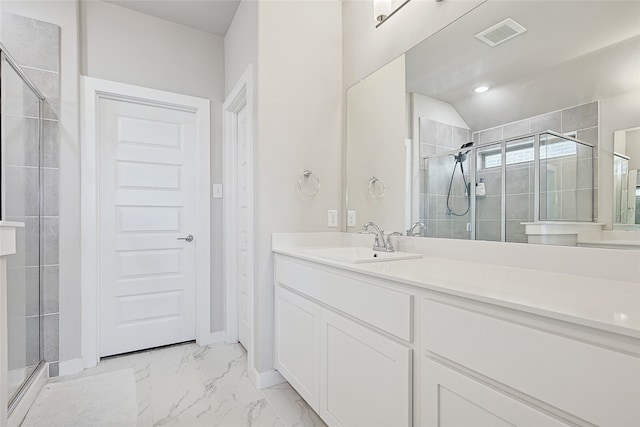 bathroom featuring a shower with door and vanity