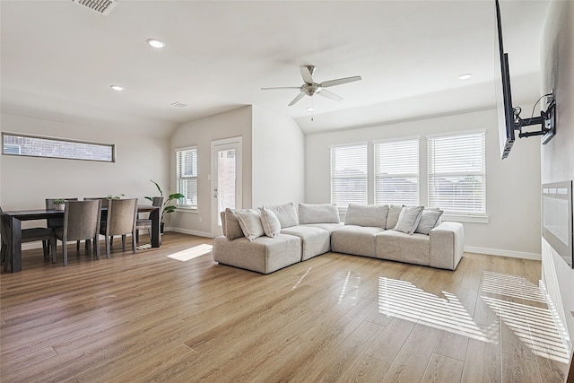 living room with light hardwood / wood-style floors, a healthy amount of sunlight, and ceiling fan