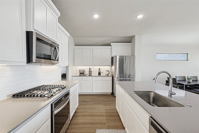 kitchen featuring dark hardwood / wood-style floors, white cabinets, stainless steel appliances, and sink