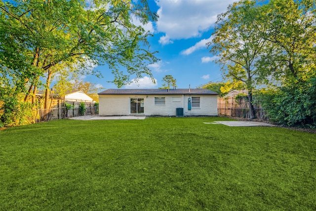 rear view of house featuring central AC unit, a patio, and a lawn