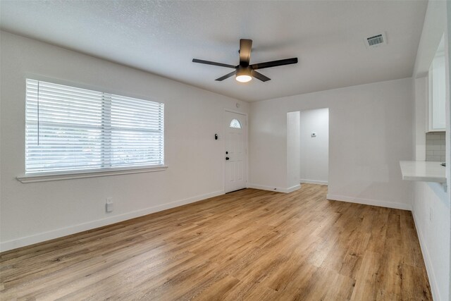 4713 San Marcus Dr, Mesquite, TX 75150 - unfurnished living room with baseboards, visible vents, light wood-style floors, and ceiling fan