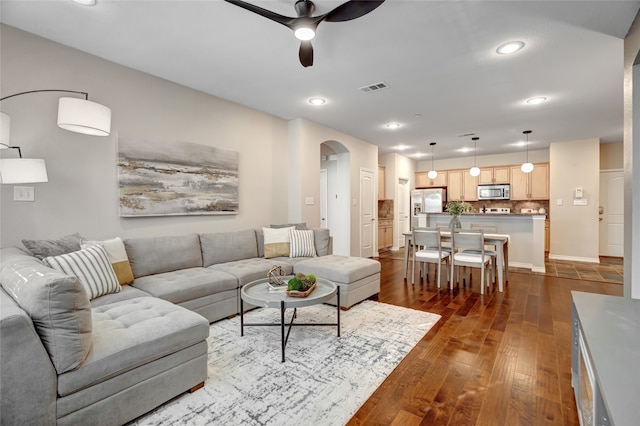 living room with ceiling fan and dark hardwood / wood-style floors