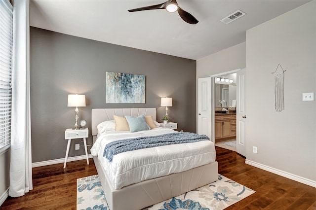 bedroom featuring ensuite bath, dark wood-type flooring, and ceiling fan