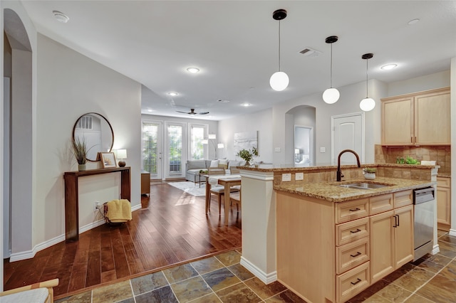 kitchen featuring sink, tasteful backsplash, dark hardwood / wood-style floors, stainless steel dishwasher, and an island with sink