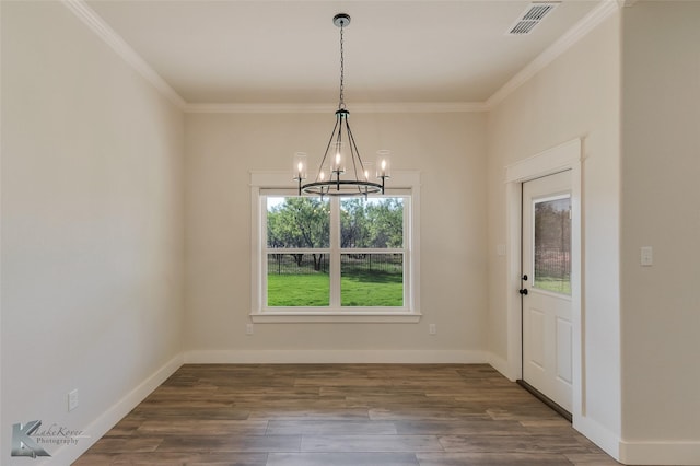 unfurnished dining area with dark hardwood / wood-style flooring, crown molding, and an inviting chandelier