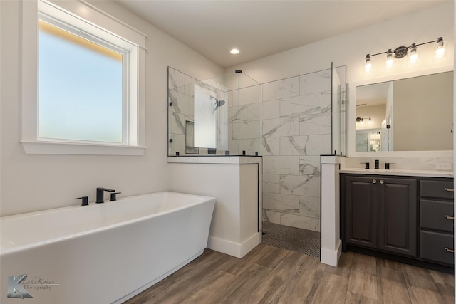 bathroom featuring vanity, separate shower and tub, and wood-type flooring