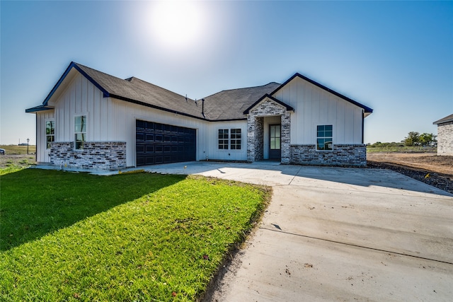 modern farmhouse featuring a front lawn and a garage