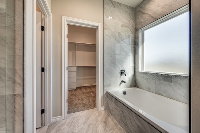 bathroom featuring a relaxing tiled tub